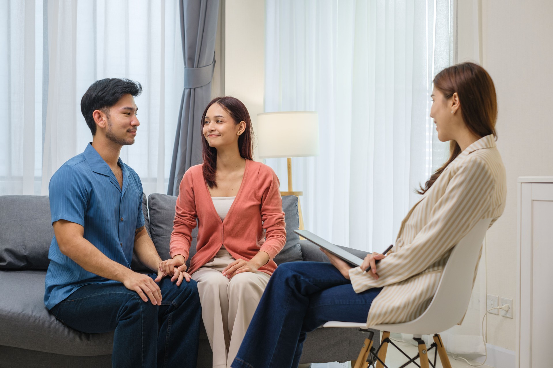 asian couple embraces happily after a productive counseling session with a therapist